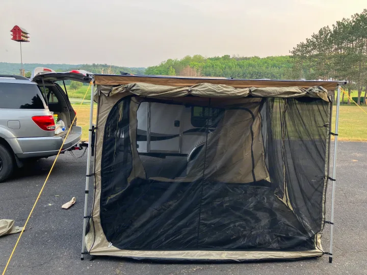 RV rental camp: SUV with awning & screen room enclosing a camper, providing shaded outdoor space.. Runaway Campers Rangerunner 2021