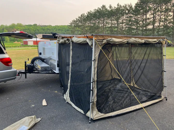 This rv rental setup features a compact travel trailer with an expansive screen room, perfect for outdoor camping comfort.. Runaway Campers Rangerunner 2021