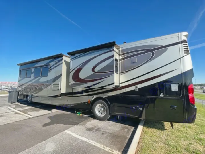 This modern luxury Class A RV rental is parked with slide-outs extended, ready for your next road trip adventure under a blue sky.. Phaeton Phaeton Motorhome 2011