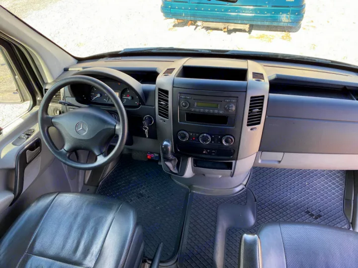 RV rental interior: Driver's view of the dashboard, steering wheel, radio, climate controls, and front seats.. Mercedes-Benz Sprinter 2012