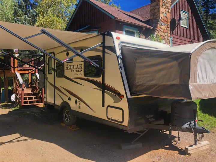 Kodiak Express Ultra-Lite travel trailer RV rental, set up with extended awning & pop-out section for outdoor living.. Dutchmen Kodiak Express 2017