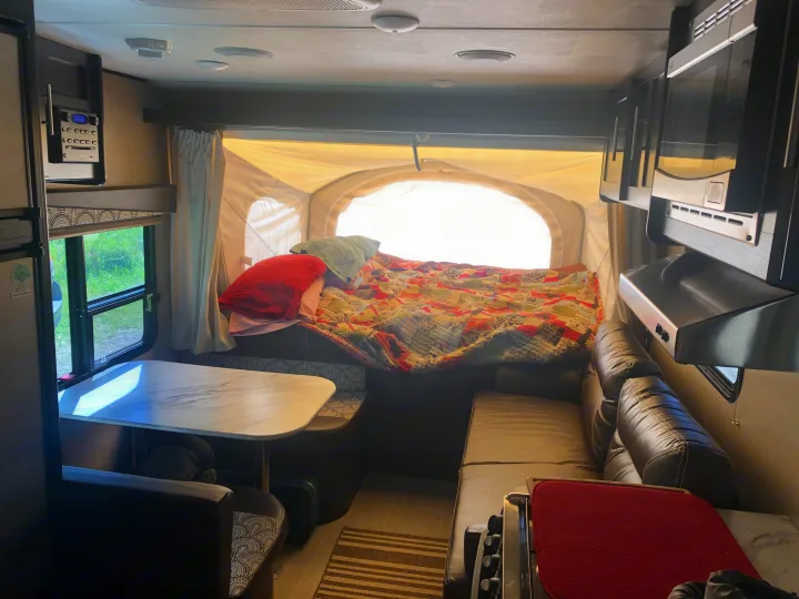 Cozy RV rental interior with pop-out bed, dinette, and kitchen for your next adventure.. Dutchmen Kodiak Express 2017