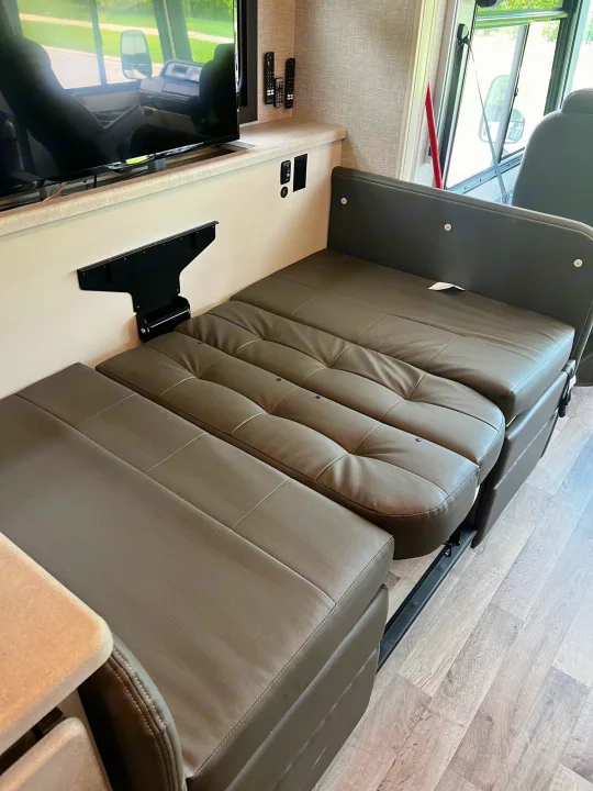 Spacious RV rental living area featuring a smart TV and a convertible sofa/dinette bed, ready for relaxation.. Entegra Vision 2023