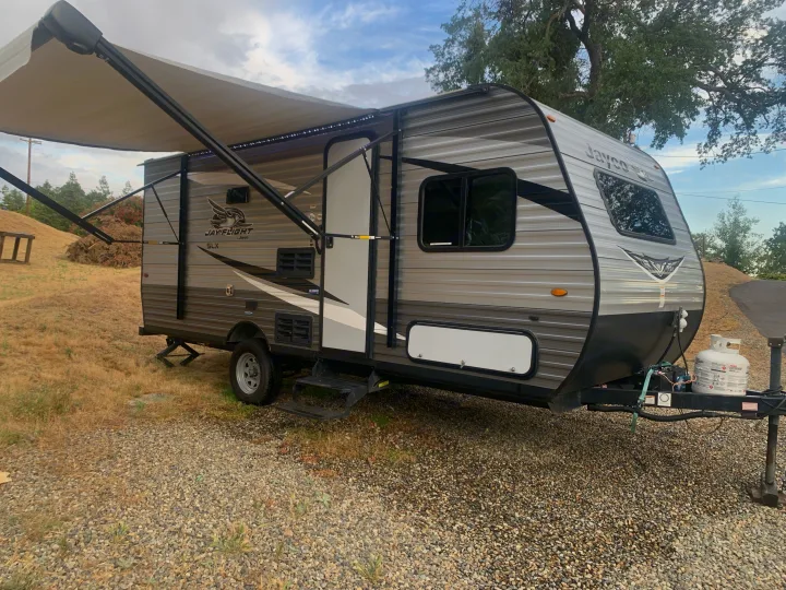 Jayco travel trailer rv rental parked on gravel with awning extended, ready for your next adventure.. Jayco Jay Flight SLX 2020