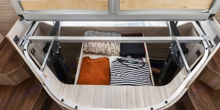RV rental smart storage: under-bed space neatly holds folded sweaters and blankets in custom compartments.. Elnagh 582 2023