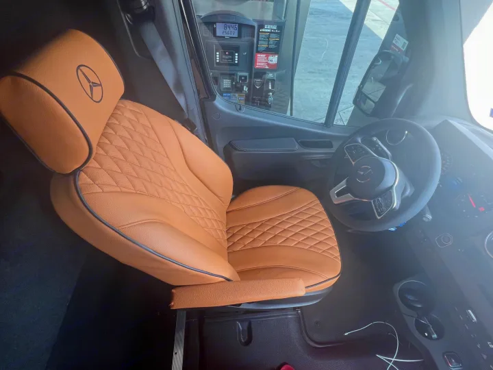 View inside a high-end RV rental: Mercedes-Benz Sprinter cab with custom tan quilted leather seat and dashboard at a gas pump.. Mercedes Benz Sprinter 2022