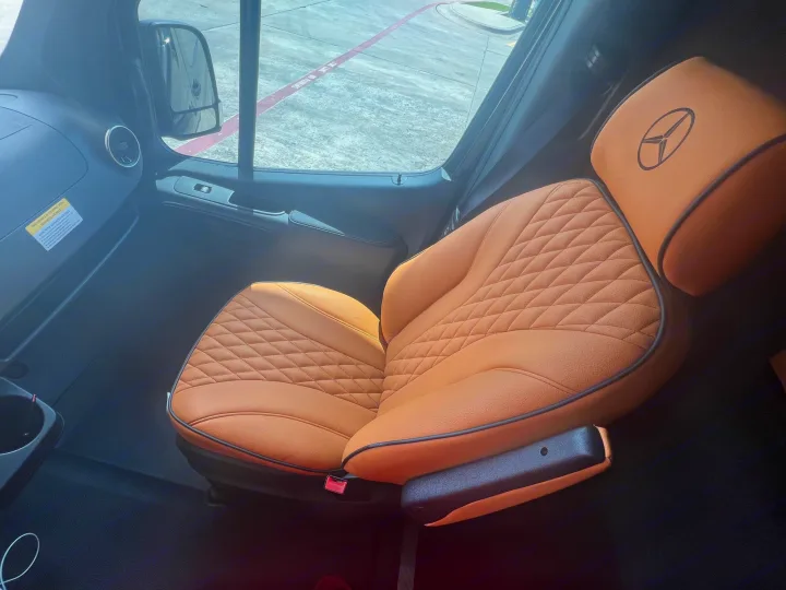 Luxury RV rental: Plush Mercedes-Benz van interior with a tan, diamond-stitched passenger seat for comfort.. Mercedes Benz Sprinter 2022