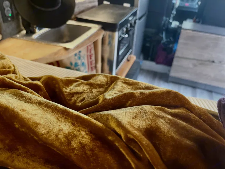Cozy RV rental interior showing a compact kitchen with a sink, oven, and golden velvet fabric.. Dodge Ram ProMaster 2500 High Top 2018
