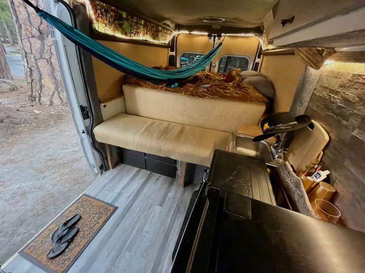 Cozy camper van interior for your next RV rental adventure. Hammock, bed, and kitchenette make it a perfect mobile home.. Dodge Ram ProMaster 2500 High Top 2018
