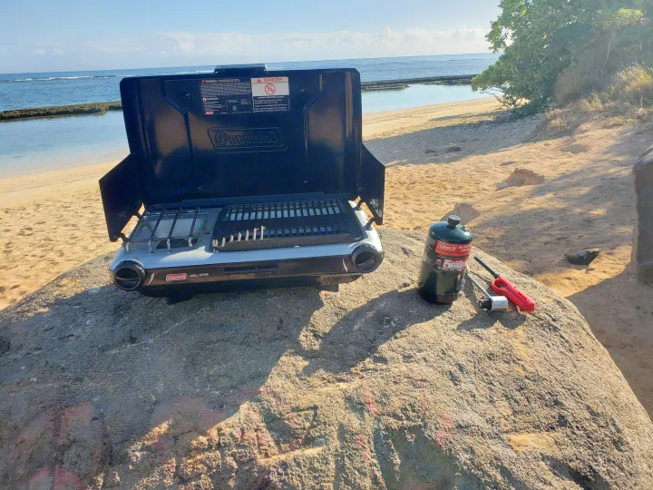 Coleman portable grill & propane tank on a rock, beachside. Great for rv rental camping & outdoor meals.. Nissan Exterra 2011