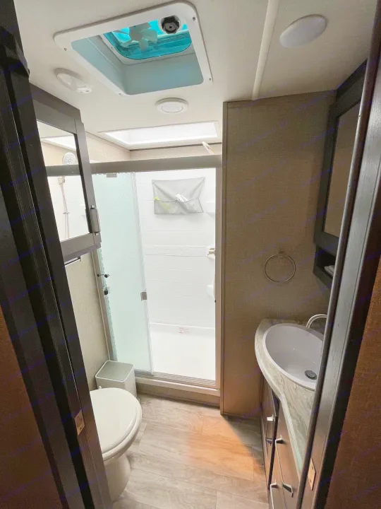 Compact RV rental bathroom with shower, toilet, and sink vanity for convenient travel.. Grand Design Reflection 2022