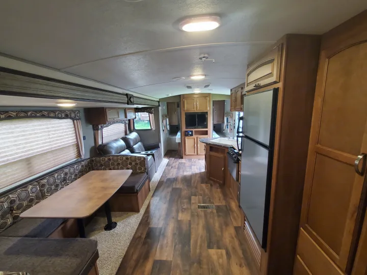 This rv rental's spacious and clean interior features a living area with a dinette and a full kitchen.. Keystone 27BHS 2017