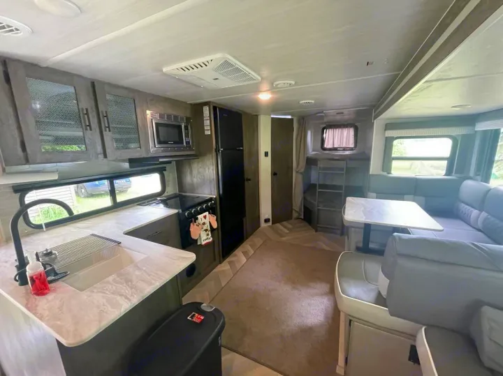 Spacious rv rental showing modern kitchen, dinette, and bunk beds inside a comfortable travel trailer.. Forest River Wildwood X-Lite 2021