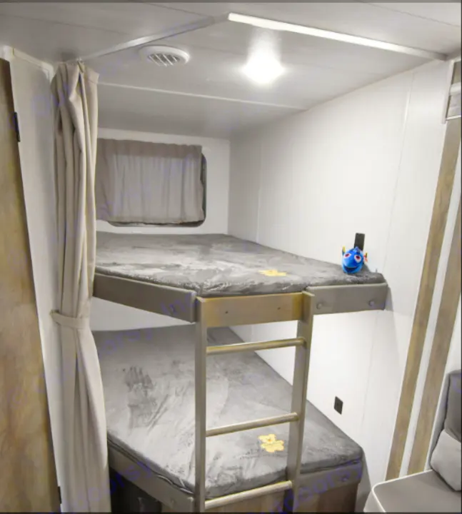 Cozy RV rental with grey bunk beds, featuring a Dory toy. Perfect for family camping adventures.. Forest River Wildwood X-Lite 2021