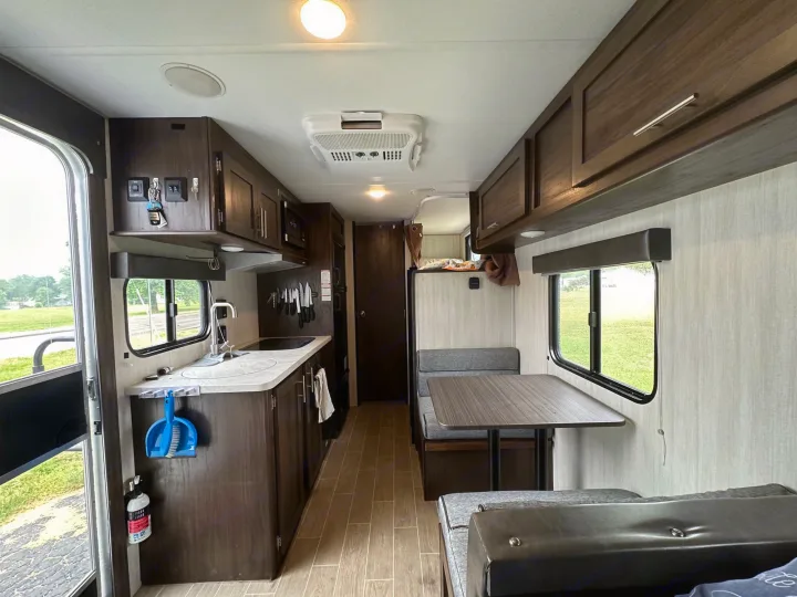 Step inside this RV rental: a well-equipped kitchen, dining booth, and comfortable living space await your next adventure.. Forest River Cherokee Wolf Pup 2020