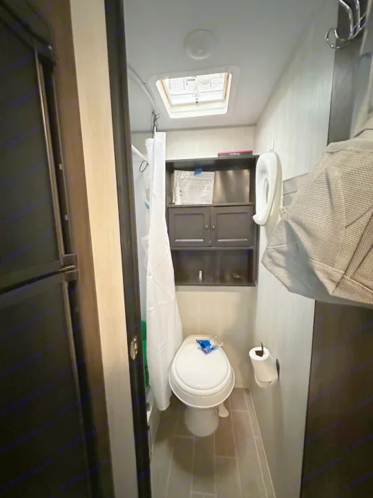 An RV rental's compact bathroom shows a toilet, shower, built-in storage, and ceiling vent, providing essential amenities.. Forest River Cherokee Wolf Pup 2020