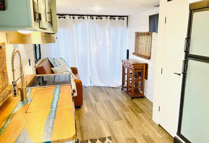 Bright RV rental interior featuring a custom wood and resin kitchen counter, light-colored walls, and cozy living space.. Forest River Cherokee Grey Wolf 2019