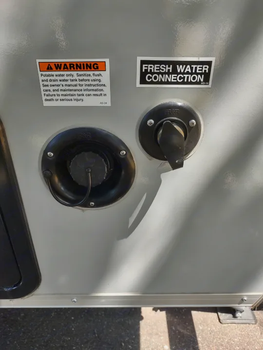 RV rental water system: fresh water connection, tank fill, and warning label for safe operation.. A Liner A Liner Popup Trailer 2022
