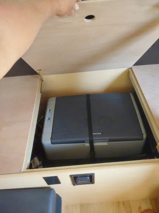 Norcold portable refrigerator strapped in a custom wooden cabinet, a smart storage solution in this RV rental.. A Liner A Liner Popup Trailer 2022