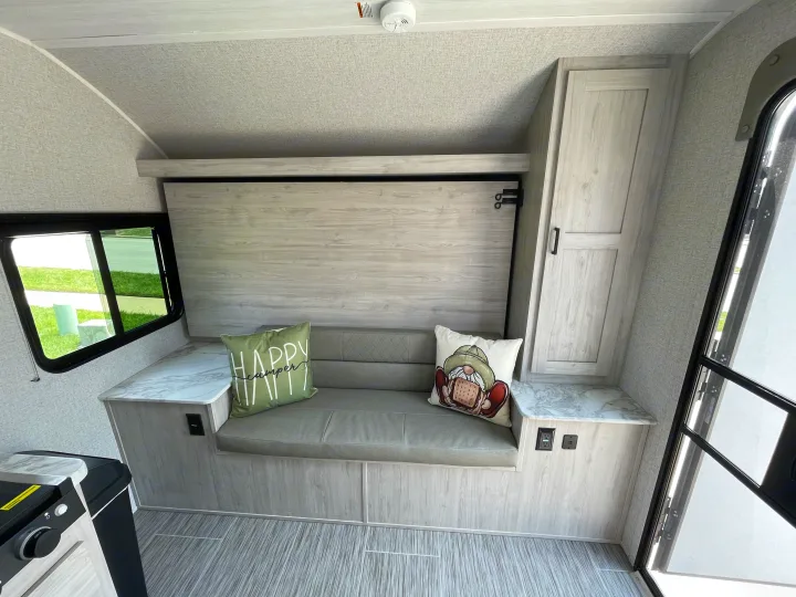 Modern RV rental interior with compact seating, window view, and kitchen. Ready for your adventures.. East to West Silver Lake LE 2023