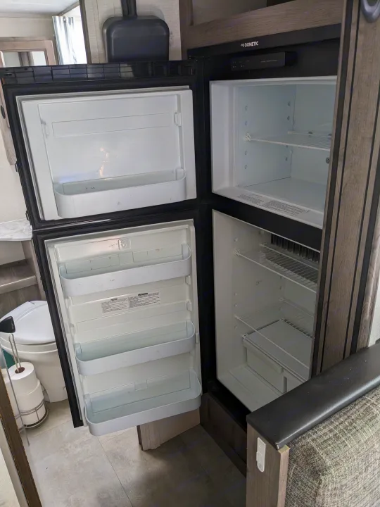 Open, empty Dometic RV refrigerator and freezer, ready for your rv rental trip inside a camper.. Coachmen Apex Nano 2021