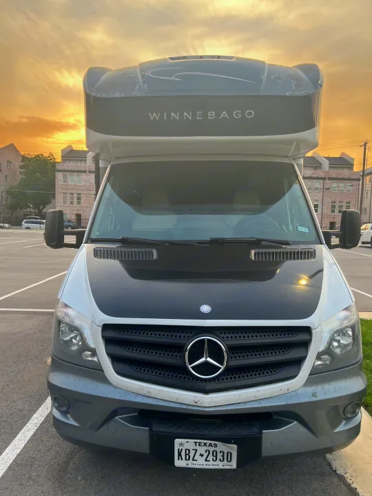 Front view of a Winnebago RV rental (Mercedes-Benz chassis) parked at sunset. Texas plate KBZ-2930.. Winnebago View 2015