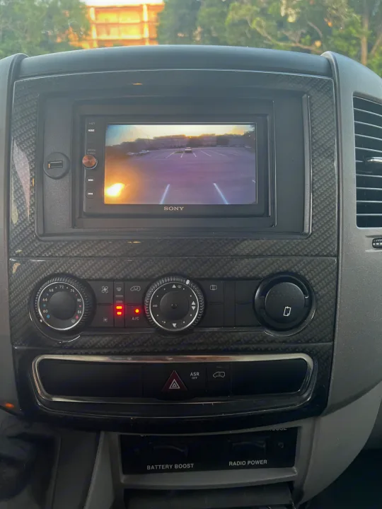 RV rental dash: Sony screen shows a backup camera, alongside climate controls, USB port, and specialized power switches.. Winnebago View 2015