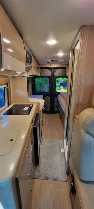 Step into this RV rental's clever interior: compact kitchen, cozy beds, and an integrated bathroom. Wood tones create a modern, inviting space.. Thor Sequence 2021