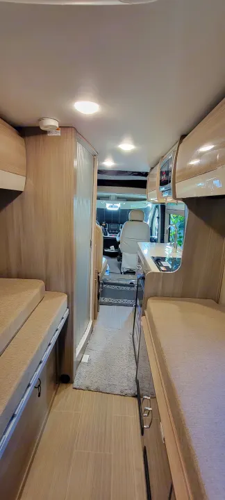 Step inside this RV rental's modern interior, featuring a compact kitchenette, cozy sleeping areas, and access to the front cabin.. Thor Sequence 2021