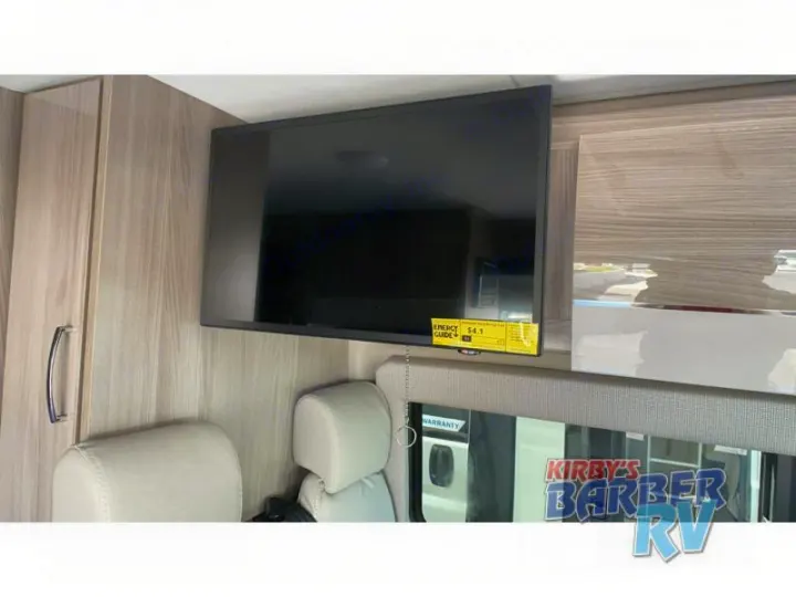 RV interior featuring a wall-mounted TV, light wood cabinetry, and comfortable seating. Perfect for your next rv rental!. Thor Sequence 2021