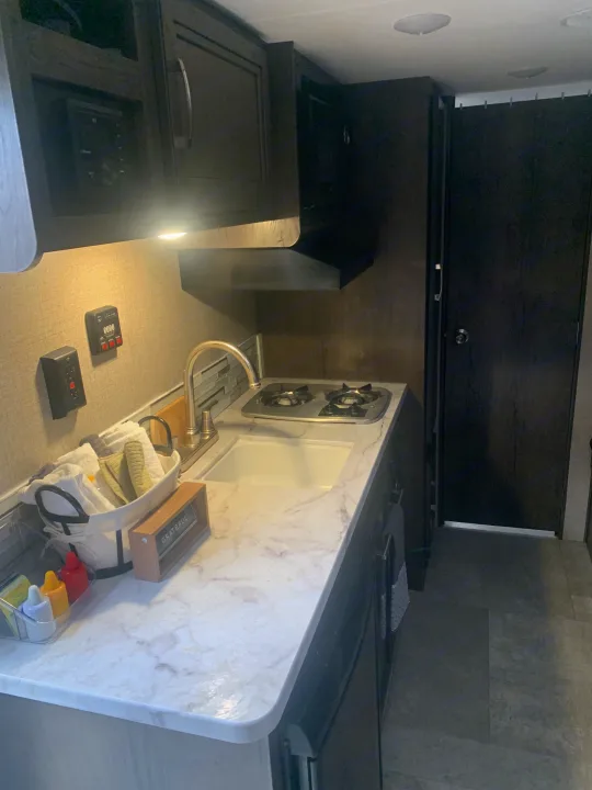 This RV rental's compact kitchen boasts a two-burner stove, sink, modern cabinets & ample counter space.. Jayco Jay Flight SLX 2020