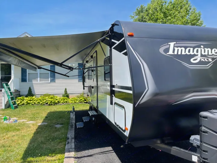 Imagine XLS travel trailer RV rental, awning extended. Perfect for a sunny day camping adventure.. Grand Design Imagine XLS 2022
