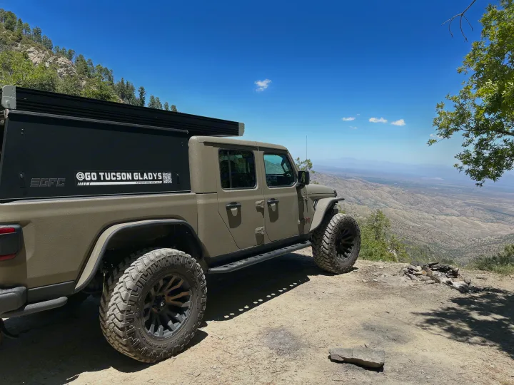 Explore with this Go Tucson Gladys RV rental Jeep Gladiator with truck camper, parked high above vast desert mountain views.. Jeep Gladiator Rubicon 2020