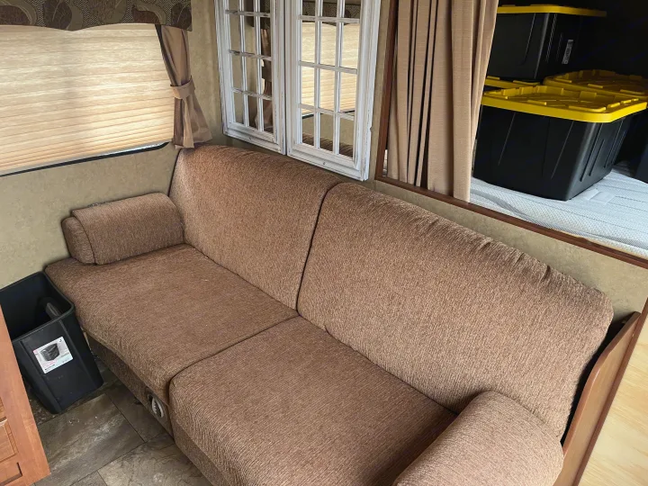RV rental interior: comfy sofa, decorative mirrors, and accessible storage bins. A cozy space for your adventure.. Jayco Jay Flight Swift 2013
