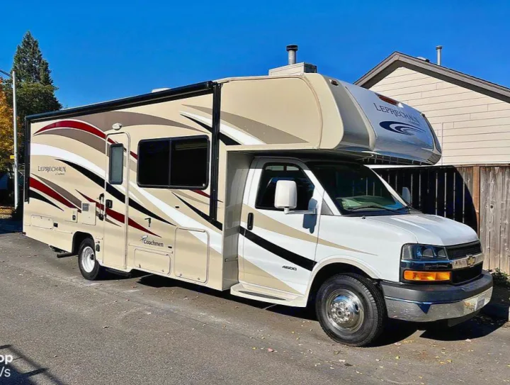 Spacious beige & white Coachmen Leprechaun RV rental, a Class C motorhome with an awning, ready for adventure.. Coachmen Leprechaun 2015