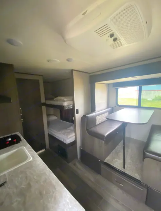 Inside this comfy RV rental: A well-appointed dinette, bunk beds, and kitchenette await your next adventure.. Jayco Jay Flight 2021