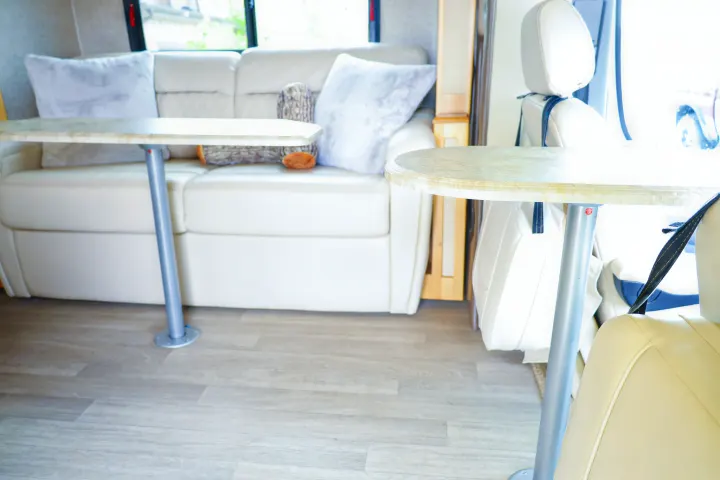 Bright, modern RV rental interior features comfortable light-colored sofa, two dining tables, and wood-look flooring.. Wayfarer Wayfarer Motorhome 2017