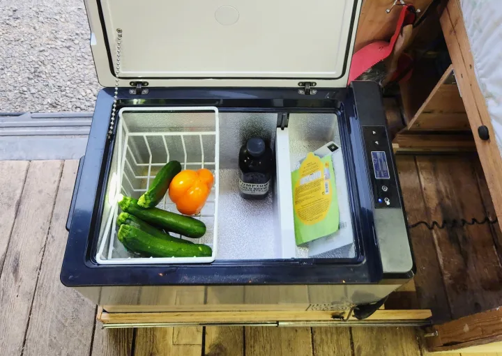 RV rental cooler storing fresh zucchini, a bell pepper, and cold brew at 42°F, ready for road trip meals.. Nissan Other 2012