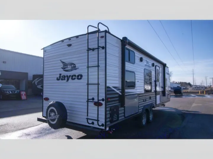 Explore the outdoors! This Jayco travel trailer, with a rear ladder and spare tire, is ready for your next RV rental.. Jayco Jay Flight SLX 2022