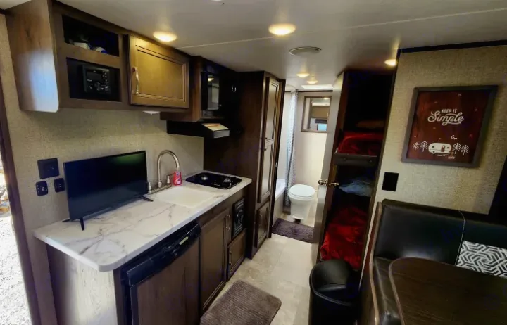 Experience this RV rental's cozy interior: kitchen, bathroom, bunk beds, and dinette. Your compact home on wheels!. Jayco Jay Flight SLX 2020