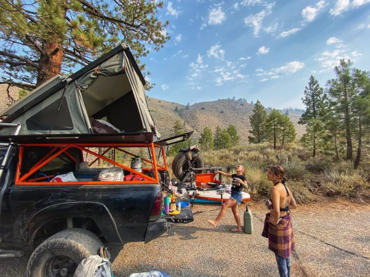 Truck with rooftop tent for camping. Cooking outdoors, an alternative to RV rental, amidst hills and pines.. Toyota Tacoma - GoFastCamper 2007