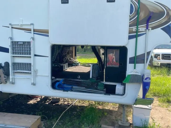 This RV rental shows its large, open pass-through storage bay packed with camping essentials and gear.. Heartland RVs Sundance 2012