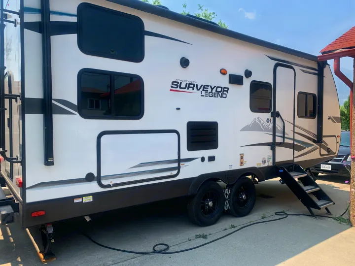 Side view of a white Forest River Surveyor Legend travel trailer, ideal for an RV rental.. Forest River Surveyor Legend 2022