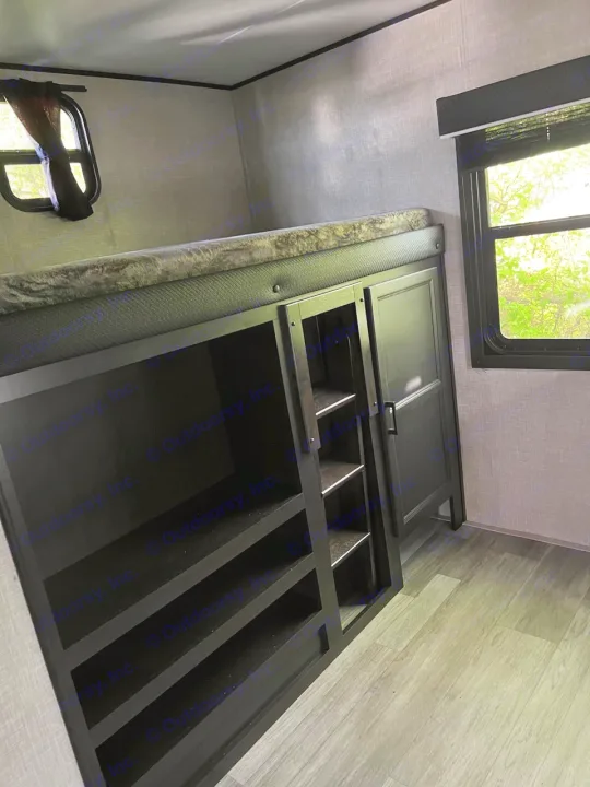 Clever RV rental bed storage: a large black organizer with multiple compartments for efficient packing.. Jayco Jay Flight 2022