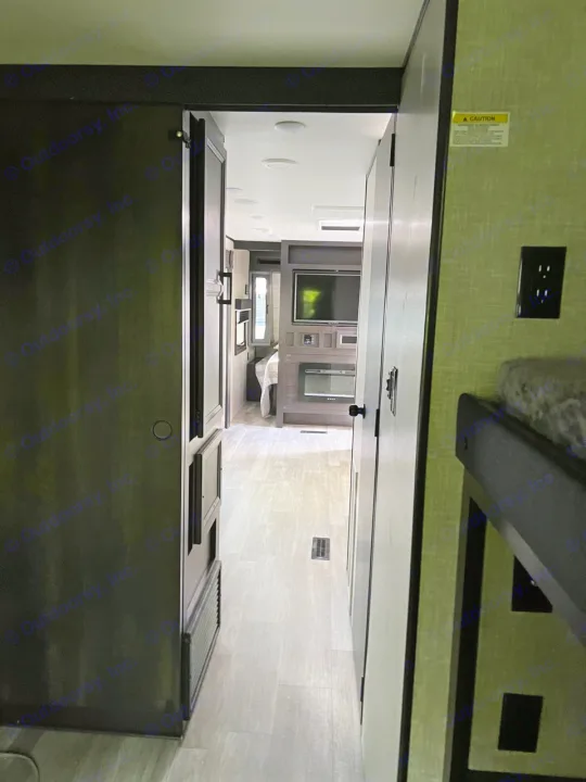 Modern RV rental interior with kitchen, living space, and sleek design. Features dark countertops, light walls, and a TV.. Jayco Jay Flight 2022