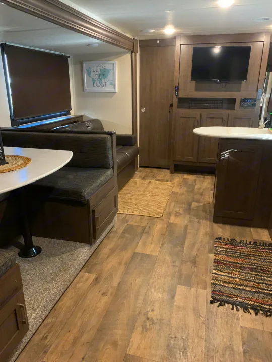 Spacious RV rental interior with dining booth, kitchen, and entertainment center for comfortable travel.. Forest River Salem Cruise Lite 2018
