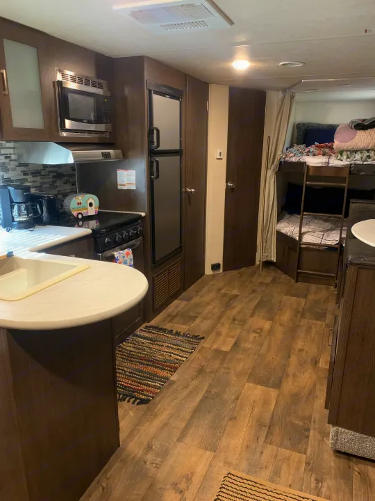 Step into this spacious RV rental, featuring a full kitchen with microwave, stove, fridge, and comfortable bunk beds.. Forest River Salem Cruise Lite 2018