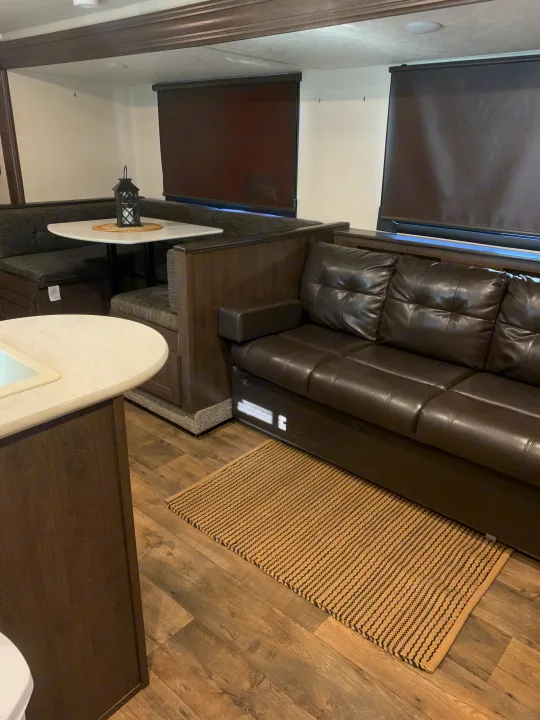 Spacious RV rental interior featuring a comfortable dinette, large leather sofa, and kitchen counter.. Forest River Salem Cruise Lite 2018