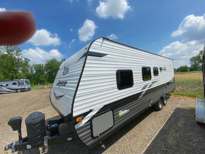 Jayco travel trailer for rv rental, parked on gravel under blue sky.. Jayco Jay Flight SLX 2022