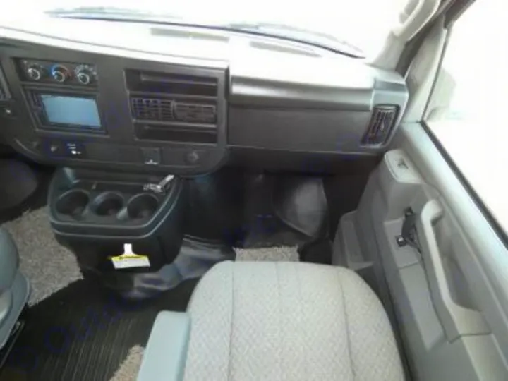View inside an RV rental: dashboard, stereo, climate controls, central cup holders, and front passenger seat.. Coachmen Freelander 27QB 2023